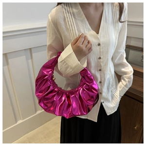 Dettaglio borsa fucsia metallizzata con texture a pieghe e finitura lucida a specchio