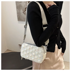 Close-up of rainbow quilted embroidery detail and silver hardware on white crossbody bag