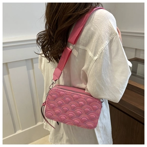 Detailed shot of quilted rainbow stitching and wide strap on pink crossbody camera bag