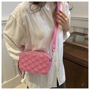 Detailed view of pink quilted camera bag with rainbow stitching and wide shoulder strap