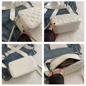 Detail view of white camera bag with rainbow quilting and adjustable wide strap
