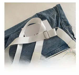 Macro shot of white quilted camera bag with rainbow stitching and wide fabric strap