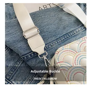Close-up of white camera bag with rainbow stitching and adjustable nylon strap details