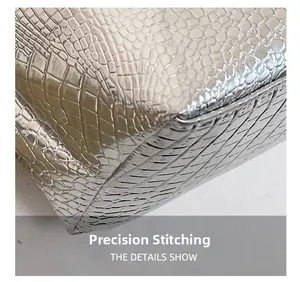 Close-up of precise stitching on silver crocodile embossed leather tote bag detail