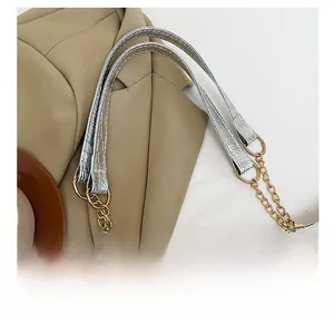 Detail of silver crocodile pattern shoulder bag with gold chain strap and stylish texture