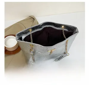 Detail showing the large interior storage and zip closure of this silver crocodile tote