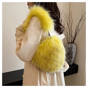 Detail einer flauschigen, hellgelben Kunstpelz-Tasche getragen zu einem eleganten beigen Trenchcoat