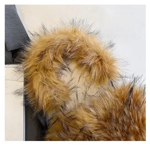 Nahaufnahme eines ingwerfarbenen Kunstfellgriffs an einer Herz-Tasche mit Mode-Magazin