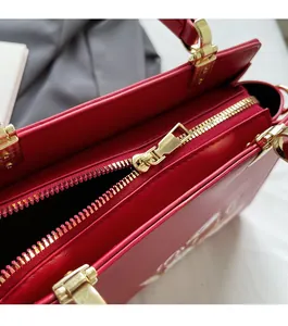 Detail of smooth gold zipper and high-quality red leather on a Chinese style tote bag