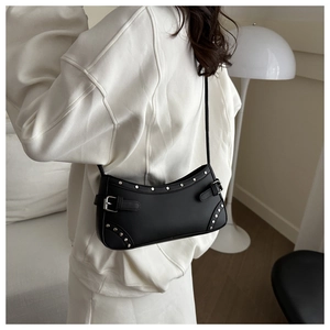 Detail of black punk baguette bag with silver studs and adjustable metal buckle