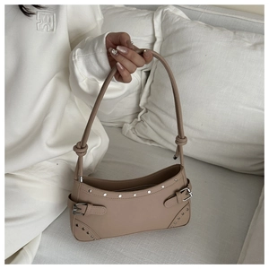 Detail showing silver rivets and adjustable metal buckles on a khaki faux leather baguette bag