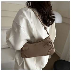 Detail of vintage khaki hobo bag featuring silver rivets and buckled strap accents