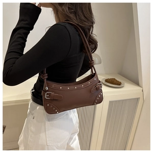 Detail view of dark brown leather shoulder bag with silver rivets and metal buckle hardware