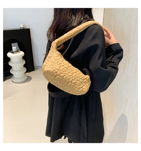 Detailed back view of a camel quilted shoulder bag with 3D floral texture on black blazer