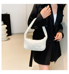 Detail of white shoulder bag featuring delicate 3D floral quilting and puffy texture