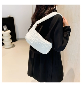 Detail of white shoulder bag featuring textured 3D floral bubbles and quilted fabric