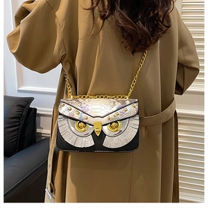 Détail du sac bandoulière hibou avec texture serpent irisée et bandoulière en chaîne
