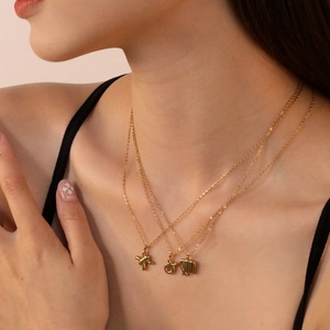 Close-up of layered 18K gold stainless steel necklaces with artistic bubble pendants