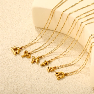 Close-up of 18K gold zodiac pendant necklaces with smooth mirror finish and O-chain