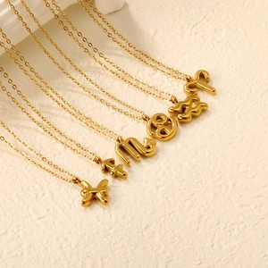 Macro detail of 18K gold zodiac bubble necklaces with puff style charms on O-chains