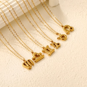 Detailed view of 18K gold zodiac bubble pendants featuring Leo, Taurus, and Gemini symbols