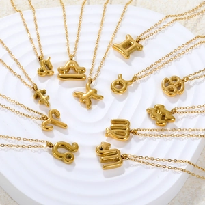 18k gold plated stainless steel zodiac pendant necklaces displayed on a round white stand