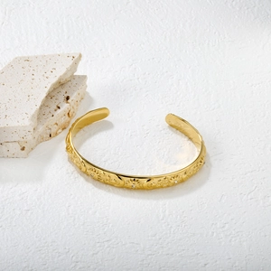 Bracelet jonc doré en forme de C avec motifs célestes soleil, lune et étoiles gravés