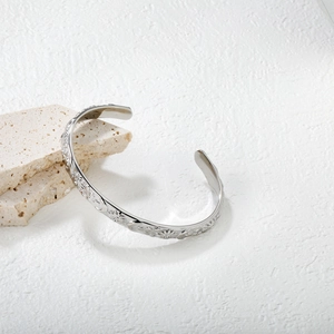 Vue détaillée du bracelet jonc argenté avec motifs célestes de soleil, lune et étoiles