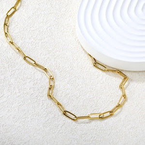 Détail du collier chaîne trombone plaqué or 18 carats sur fond en pierre texturée