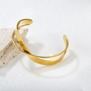 Minimalist 18k gold irregular cross bangle featuring a polished geometric open design
