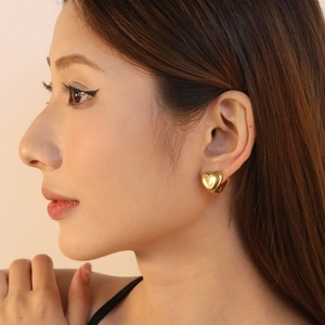 Elegant 18K gold plated heart stud earrings shown on model for minimalist daily style