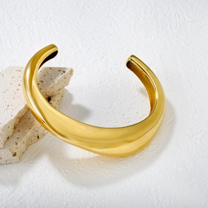 Polished 18K gold stainless steel wide C-shaped open cuff bangle on stone base