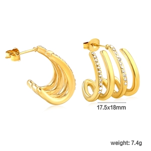 Detail of gold C-shaped multi-layer earrings with sparkling rhinestones and ear plugs