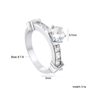 Bague classique argentée avec zircon rond et accents latéraux sur fond blanc épuré