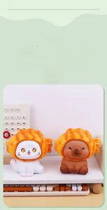Gros plan de figurines chat et capybara avec chapeaux de croissant sur un bureau