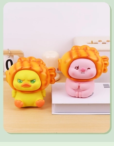 Détail de figurines canard et cochon avec chapeaux taiyaki sur un bureau en bois