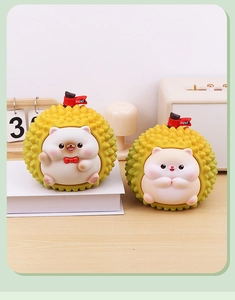 Detail of adorable durian hedgehog money box with Suki flag on a wooden desk