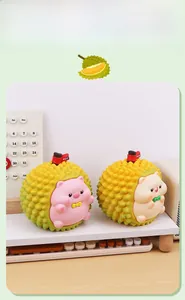 Detail view of pink and white durian-shaped piggy banks with cute cat and pig characters