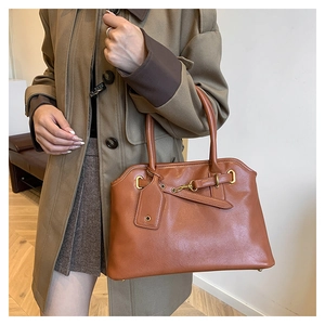 Vue détaillée du grand sac Boston marron avec ferrures dorées et lanières en cuir