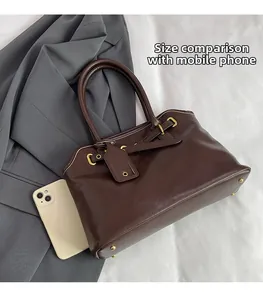 Détail du grand sac Boston marron avec smartphone pour comparaison de taille réelle