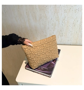 Detail of khaki quilted handbag showing 3D floral stitching and soft padded texture