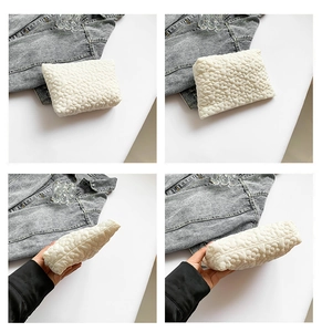 Detail view of white quilted cosmetic bag with unique 3D flower-shaped texture