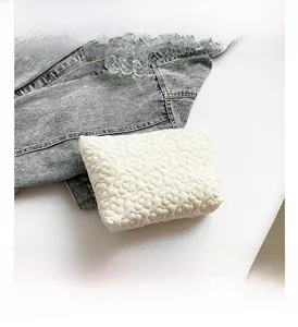 Close-up of white quilted bubble texture fabric on a minimalist fashion envelope clutch bag