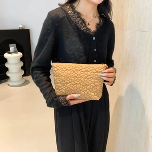Chic camel quilted clutch bag with 3D flower pattern shown in a stylish lifestyle setting