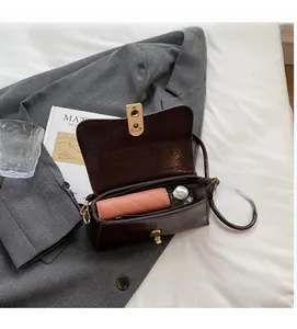 Détail d'un sac porté épaule en cuir marron montrant l'espace de rangement intérieur