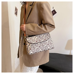 Dettaglio della borsa monogram vintage con tracolla in pelle indossata su un blazer