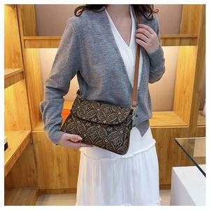 Dettaglio della borsa a tracolla vintage marrone con monogramma e finiture dorate