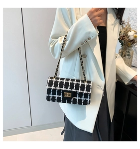 Détail du sac en tweed à carreaux noir et blanc avec chaîne dorée et fermoir rotatif