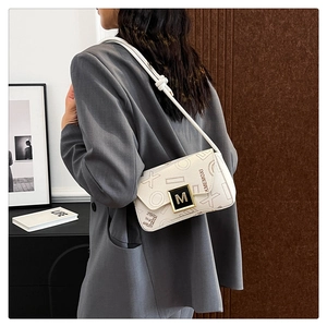 Detail of white embossed leather underarm bag with metal M-buckle and KMEMOXI print