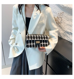 Détail du sac bandoulière en tweed noir et blanc avec fermoir tournant doré et chaîne